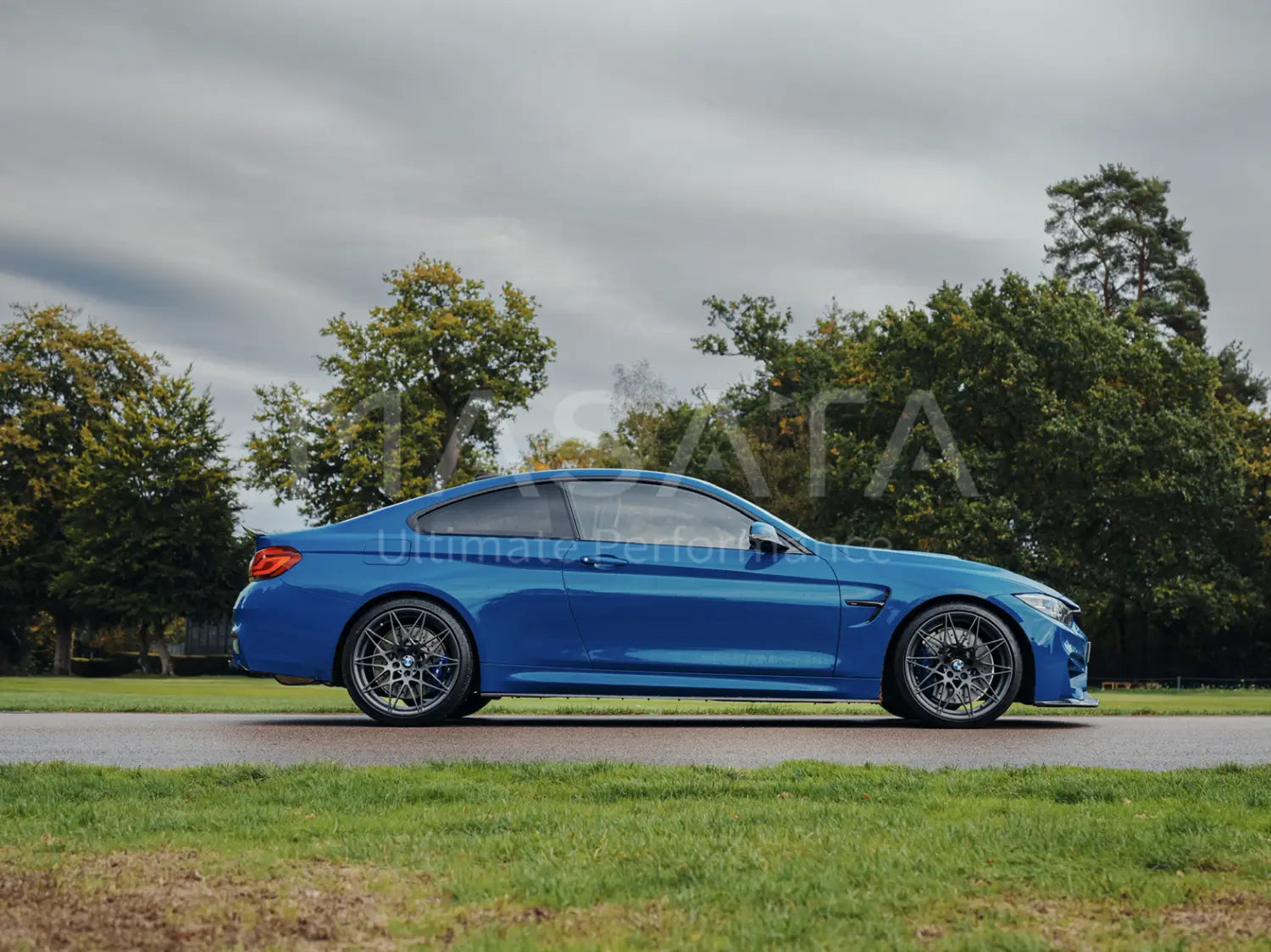 Bright blue BMW M4 coupe with dark alloy wheels showcasing Masata BMW F80 performance springs.